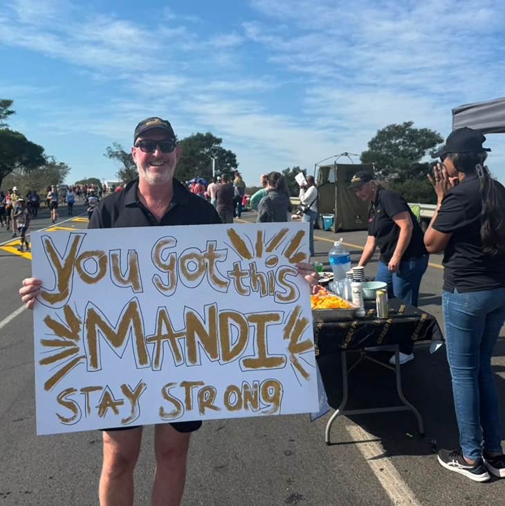 Gerber Paper supporter encouraging a Comrades Marathon runner with a handmade sign