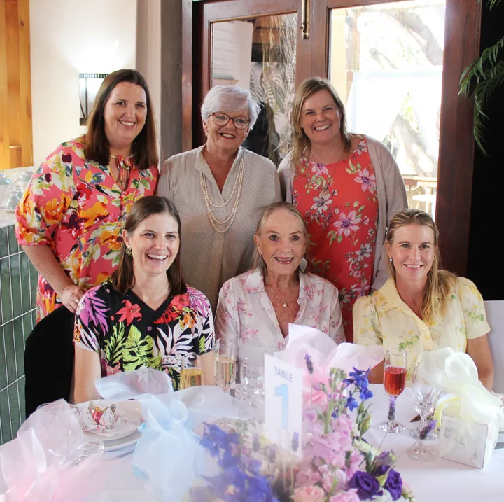 Guests gathered around a table with flowers at Gerber Paper’s annual Ladies’ Tea.