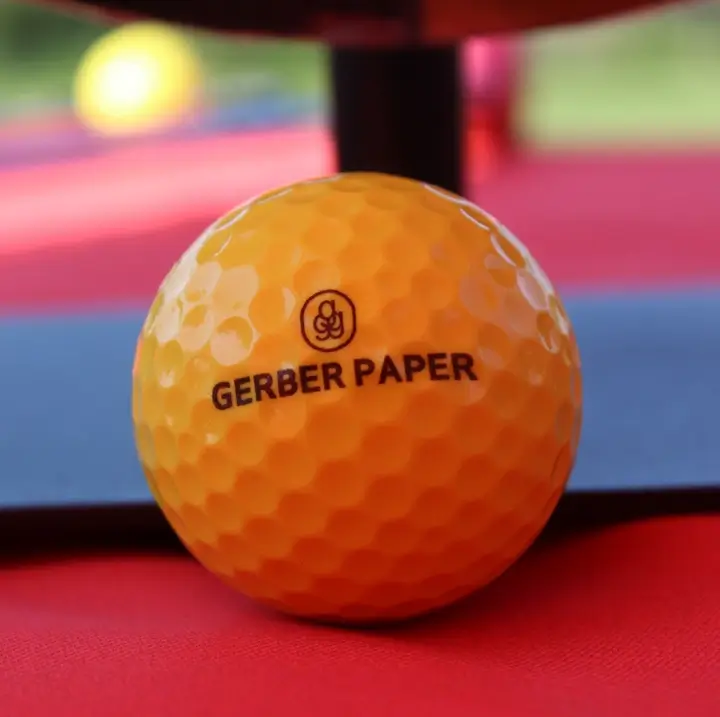 Close-up of a Gerber Paper branded golf ball on the course.